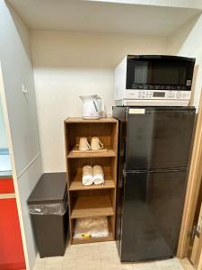 eine kleine Küche mit Mikrowelle und Kühlschrank in der Unterkunft # 3 Katsu House日本桥地铁站6分 in Wada + 10 Fotos