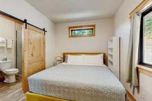 a bedroom with a bed and a toilet and a window at Rocky Crest Retreat in Somers