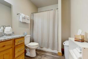 a bathroom with a toilet and a shower curtain at Rocky Crest Retreat in Kalispell +36 photos