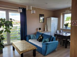 a living room with a blue couch and a table at Malinowa 36 Apartamenty in Chojnice