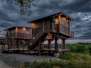 a tree house on a platform with stairs at "Land of the Free, Home of the Brave" Double Luxury Treehouse for 12 Near Dollywood & Pigeon Forge in Catlettsburg +8 photos