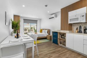 a kitchen and living room with a bed in a room at Modern Studio w/ Pool, Gym & Rooftop Palm Beach in Palm-Eagle Beach