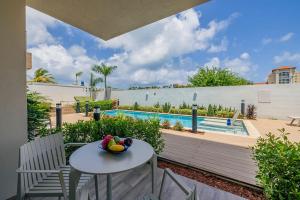a bowl of fruit sitting on a table next to a pool at Modern Studio w/ Pool, Gym & Rooftop Palm Beach in Palm-Eagle Beach