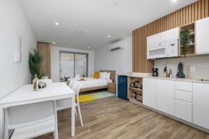 a kitchen and living room with a bed in the background at BRAND NEW Studio w/Pool, GYM, Rooftop @ Palm Beach in Palm-Eagle Beach