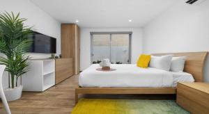 a bedroom with a large white bed and a tv at BRAND NEW Studio w/Pool, GYM, Rooftop @ Palm Beach in Palm-Eagle Beach