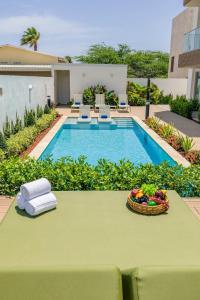 a table with a bowl of fruit next to a pool at BRAND NEW Studio w/Pool, GYM, Rooftop @ Palm Beach in Palm-Eagle Beach