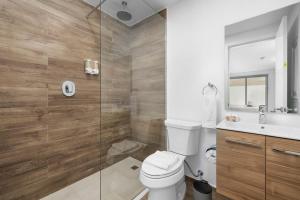 a bathroom with a toilet and a glass shower at BRAND NEW Studio w/Pool, GYM, Rooftop @ Palm Beach in Palm-Eagle Beach +19 photos