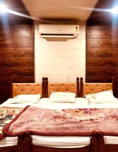 a bedroom with a large bed and a air conditioner at Singh Hotel's Shubhadra Guest House in Mathura