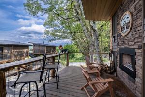 une terrasse couverte avec des chaises et une cheminée dans une maison dans l'établissement "Morning Wood" Luxury Treehouse Retreat Near Dollywood & Pigeon Forge, à Catlettsburg