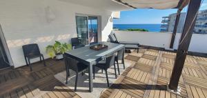 einen Tisch und Stühle auf einem Balkon mit Meerblick in der Unterkunft Ático con gran terraza, vistas y plaza de parking in Blanes