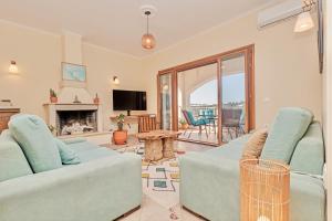 a living room with two couches and a fireplace at Villa Anafoufou Afionas with private heatable pool in Afionas