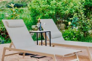 two white chairs and a table with wine glasses at Villa Anafoufou Afionas with private heatable pool in Afionas