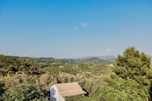 a building in the middle of a field with trees at Villa Anafoufou Afionas with private heatable pool in Afionas +30 photos