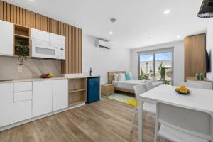 a kitchen and living room with a table and chairs at NEW Modern Studio w/ Pool & Gym I Walk 2 PalmBeach in Palm-Eagle Beach