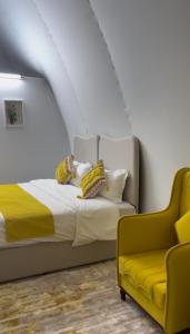 Un dormitorio con una cama y una silla amarilla. en Amara Camp, en Al Raka