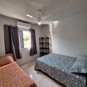 a bedroom with two beds and a window at bairro Jardim Parati - casa 2 quartos em condomínio in Campo Grande