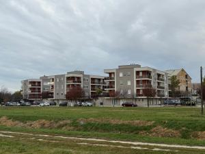 a large apartment complex with cars parked in a field at HIGHWAY Apartman in Győr