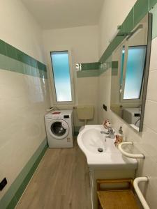 a bathroom with a sink and a washing machine at Studio Lido 10 in Lido delle Nazioni