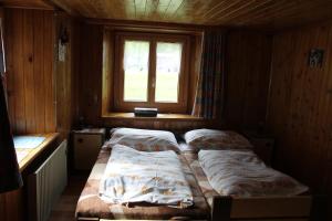 two beds in a room with a window at Chalet Talblick, alte Gasse 40 in Saas-Grund