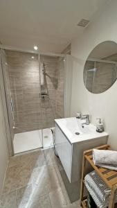 une salle de bain blanche avec une douche et un lavabo dans l'établissement Le clos du bon temps, à Sainte-Marie-de-Vaux