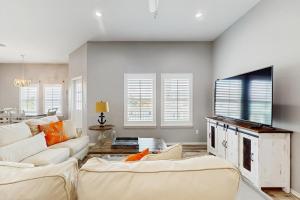 a living room with white furniture and a flat screen tv at Gulf Breeze in Rockport