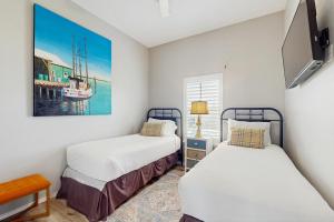 a bedroom with two beds and a painting on the wall at Gulf Breeze in Rockport +14 photos