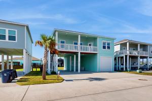 a house with a palm tree in front of it at Gulf Breeze in Rockport