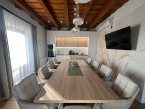 a living room with a large wooden table and chairs at HorizOND Vendégház in Szerencs