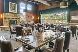 ein Esszimmer mit Tischen und Stühlen und einem Kamin in der Unterkunft Tamarron 822 in Rockwood