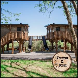 a playground with two decks and a house at "Tarzan & Jane" Jungle-Themed Double Luxury Family Treehouse for 12 Near Dollywood & Pigeon Forge in Sevierville