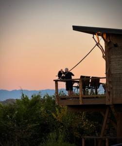 two people standing on a deck looking at the sunset at "Tarzan & Jane" Jungle-Themed Double Luxury Family Treehouse for 12 Near Dollywood & Pigeon Forge in Sevierville +7 photos