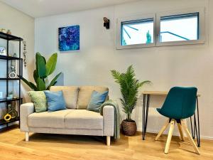 a living room with a couch and two plants at Modern Business Studio with Self check-in in Schaan