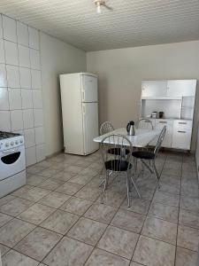 a kitchen with a table and a white refrigerator at Casa no centro in Mineiros