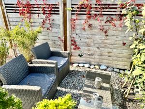a patio with two wicker chairs and a fence at Modern Business Studio with Self check-in in Schaan