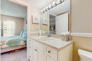 ein Badezimmer mit Waschbecken und Spiegel und einem Bett in der Unterkunft The Palm Collection in Marco Island + 15 Fotos