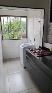 a white kitchen with a stove and a sink at Modern Apartment in São Caetano do Sul in São Caetano do Sul