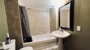 a bathroom with a sink and a toilet and a bath tub at Private Rooms Close to NAIT Guest House For Men Only in Edmonton
