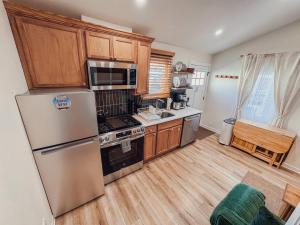 a kitchen with stainless steel appliances and wooden cabinets at Stylish 2 BR 1 BA Apartment - Steps to the Ocean - Hidden Gem in Wildwood