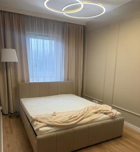 a bedroom with a bed in a room with a chandelier at Apartament 69 in Łomża