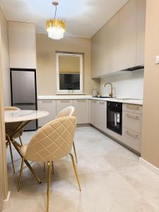 a kitchen with white cabinets and a table and chairs at Apartament 69 in Łomża