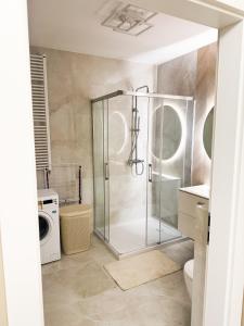 a bathroom with a shower and a washing machine at Apartament 69 in Łomża
