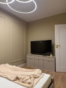 a bedroom with a flat screen tv and a bed at Aureo Residence in Łomża