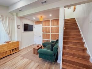 a living room with a green couch and stairs at Stylish 2 BR 1 BA Apartment - Steps to the Ocean - Hidden Gem in Wildwood