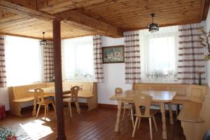a dining room with a table and chairs and windows at Ferienhaus Riegler in Sankt Georgen bei Neumarkt