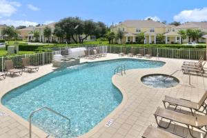 a swimming pool with benches and chairs in a courtyard at Stylish 3-BR with Private Pool & Conservation View in Orlando