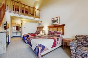 a bedroom with two beds and a chair and a staircase at Dells Den Condo #7306 in Wisconsin Dells
