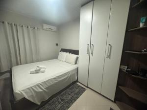 Habitación pequeña con cama y armario en Cavalinho Branco 305 suíte com varanda, en Águas de Lindóia 21 fotos más