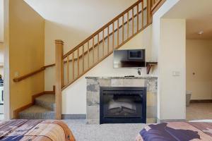a living room with a fireplace and a staircase at Dells Den Condo #7306 in Wisconsin Dells