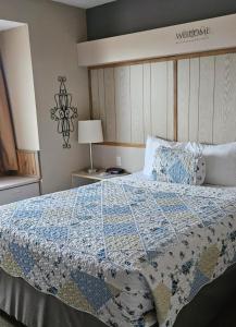 a bedroom with a bed with a quilt on it at Patti's Inn and Suites in Grand Rivers