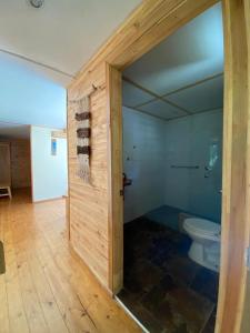 a bathroom with a toilet in a room at Posada de Expediciones Kahuel in Chaitén